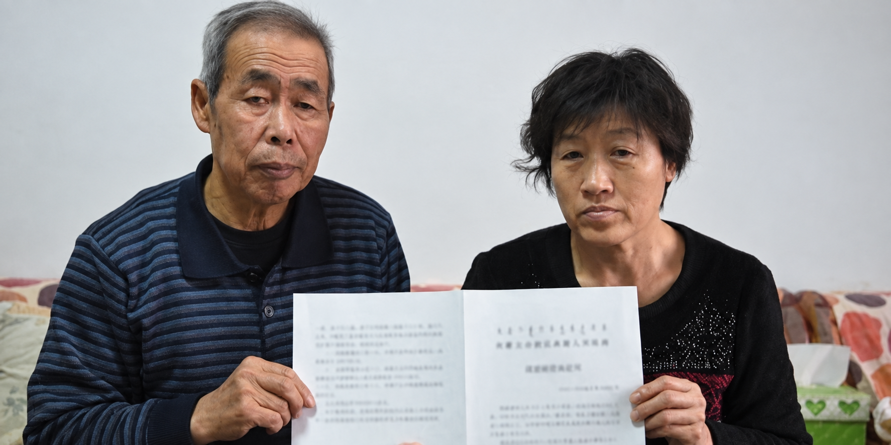 Hugjiltu’s parents holding a document, in an AI-enhanced version of the original photograph